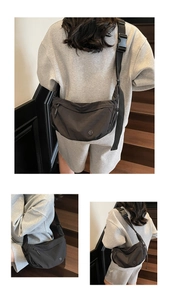 Detail of black crescent crossbody bag with silver logo and adjustable wide strap