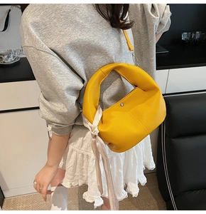Détail du sac cabas en cuir jaune avec accessoire foulard en soie et bandoulière