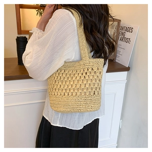 Détail du motif losange ajouré tissé à la main sur un sac fourre-tout beige en paille