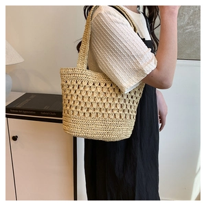 Vue détaillée du sac cabas en paille tissé à la main avec motifs ondulés ajourés élégants