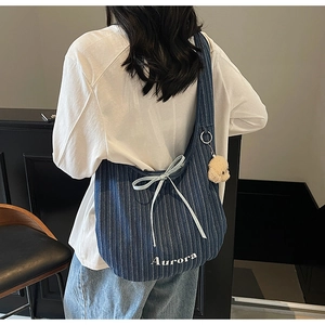 Detail of blue striped canvas shoulder bag with Aurora embroidery and white silk bow