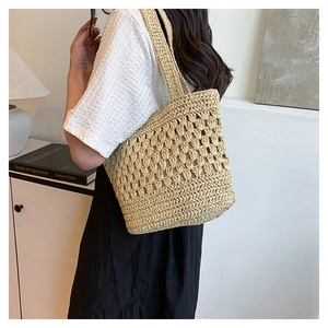 Détail du sac cabas en paille tricoté main montrant la texture crochetée et les lanières