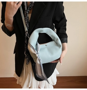 Detail of light blue lychee pattern leather tote bag with silk scarf and thin strap