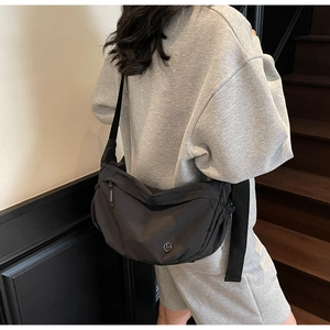 Detail of black crescent crossbody bag in waterproof nylon with adjustable shoulder strap