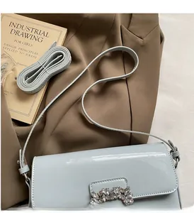 Detail of light blue patent leather handbag with crystal-embellished square buckle accent
