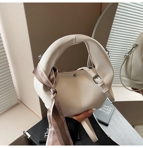 Détail du sac à main blanc en cuir grainé avec anse ronde et foulard décoratif en soie