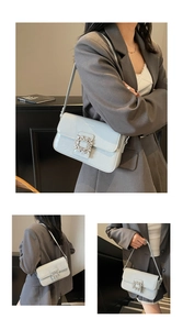 Detailed close-up of light blue patent leather shoulder bag with crystal buckle