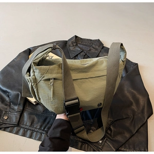 Detailed close-up of the durable army green nylon bag featuring a quick-release buckle