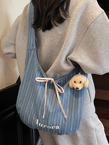 Blue striped denim underarm bag with pink bows and a cute plush puppy keychain