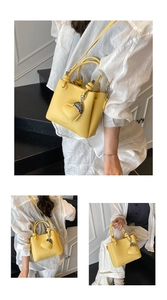 Détail du sac seau jaune à texture litchi avec pendentif coeur et fine bandoulière