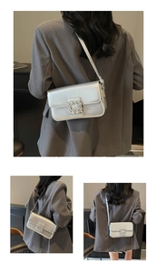 Detail of silver metallic handbag with rectangular rhinestone buckle on a grey suit