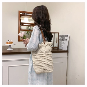 Détail du sac cabas au crochet montrant la texture beige tissée et la bandoulière en cuir