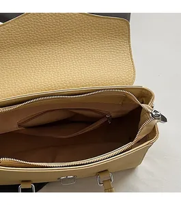 Macro detail of yellow pebble leather handbag interior with silver zipper pocket