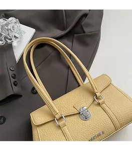 Close-up of beige lychee grain leather underarm bag with silver rotating metal lock detail