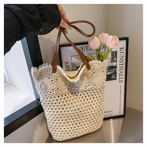 Détail d'un sac cabas tissé ajouré avec anses en cuir marron et décor de tulipes