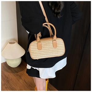 Detail of hand-woven straw crossbody bag featuring premium camel PU leather trim and straps