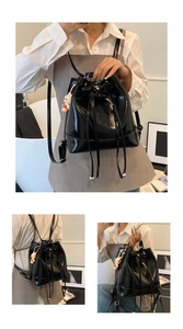 Detail of black glossy bucket bag featuring drawstring closure and white bunny pendant
