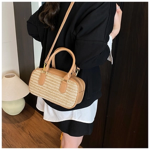 Detailed view of women straw woven crossbody bag with brown leather accents and straps