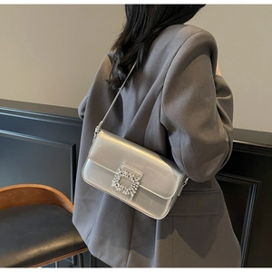Silver rhinestone square buckle baguette bag styled on shoulder with chic grey blazer