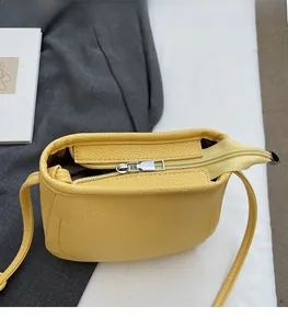 Close-up of the smooth silver zipper and litchi texture leather on a yellow bucket bag