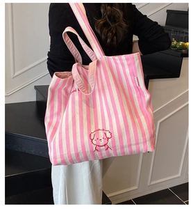 Close-up of pink striped canvas tote bag featuring a red cartoon puppy embroidery detail