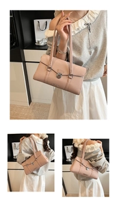 Detail of pink pebbled leather underarm bag with silver rotating lock and brand logo
