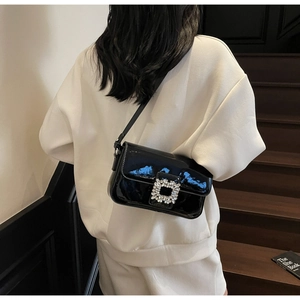 Detailed shot of black patent leather shoulder bag featuring a silver crystal square buckle