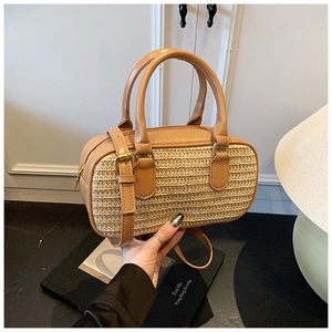 Detail showing woven raffia texture and tan leather trim on the fashion shoulder bag