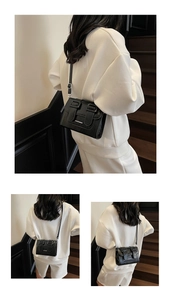 Detail of black leather satchel with dual vertical straps and adjustable shoulder strap