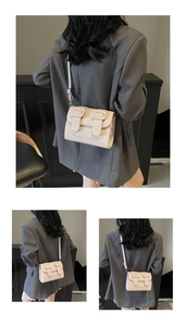 Detail of light apricot leather satchel bag with stylish double buckles and adjustable strap