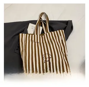 Detailed texture of striped canvas tote bag with cartoon dog and Good Life embroidery