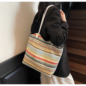 Close-up of colorful striped woven straw tote bag with chunky cotton rope handles