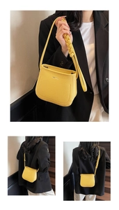 Detail of yellow lychee leather bucket bag with a stylish braided shoulder strap design