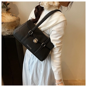 Detail of black pebbled leather underarm bag with silver turn-lock and fine shoulder straps
