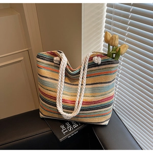 Detail of colorful striped woven tote bag with white cotton rope handle on seat