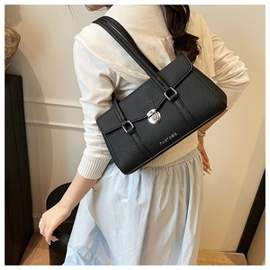 Detail of black pebbled leather underarm bag with silver buckle and brand logo