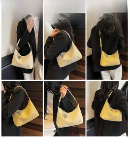 Detail shots of yellow crescent shoulder bag with heart charm and adjustable strap
