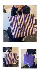 Detail view of purple striped canvas tote bag with dog illustration and slogan text