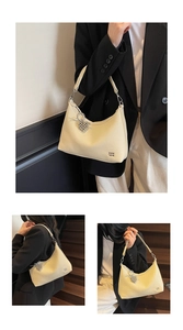 Detail of hobo bag in cream pebbled leather with silver heart charm and branded logo