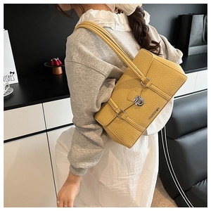 Detail of yellow lychee pattern PU underarm bag with silver twist lock and slim straps