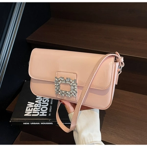 Detailed close-up of pink patent leather handbag with a sparkling square crystal buckle