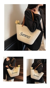 Detail of woven straw tote bag featuring black Summer embroidery and brown leather handles