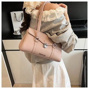 Detail of pink pebbled leather shoulder bag with silver metal twist lock and logo