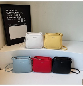 Minimalist faux leather crossbody bucket bags in five vibrant colors displayed on white steps