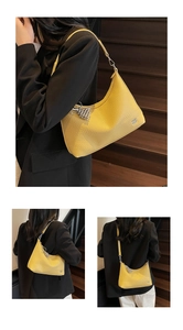 Detail of yellow crescent shoulder bag in lychee leather with grape metal charm