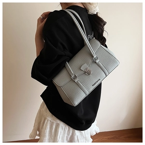 Detail view of the silver metal swivel lock and pebble grain leather on the shoulder bag