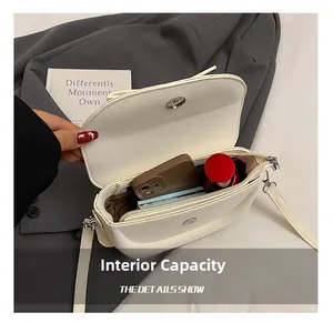 Vue intérieure du sac bandoulière blanc avec poche zippée et emplacements pour cartes