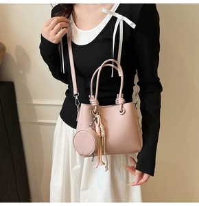 Borsa a mano rosa in pelle martellata con piccolo portamonete e dettagli nappe