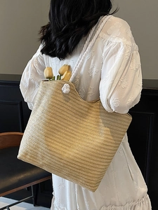 Minimalist beige woven straw tote bag with white rope handles and flower detail for summer