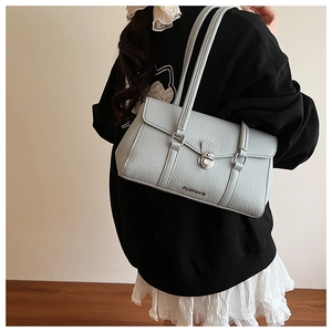 Detail view of light blue lychee pattern leather shoulder bag with silver lock and logo